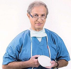 doctor holds implant for breast augmentation